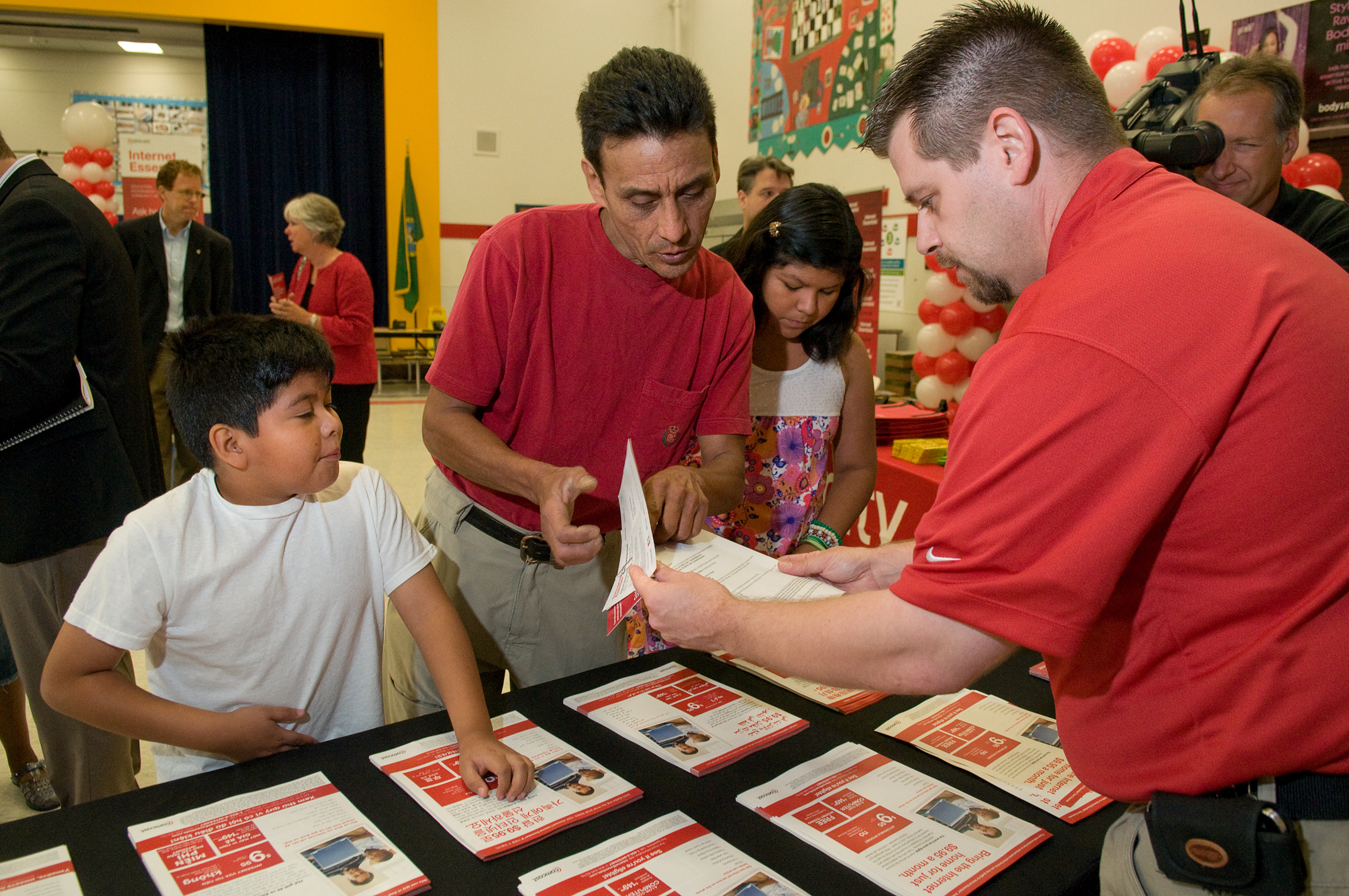 parent and employee talking about Internet Essentials as child watches