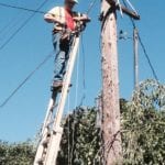 Comcast tech stringing cable on a pole