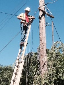 Comcast tech stringing cable on a pole