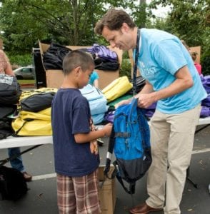 adult giving child a backpack