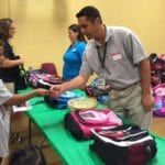 People picking up backpacks