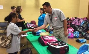 People picking up backpacks