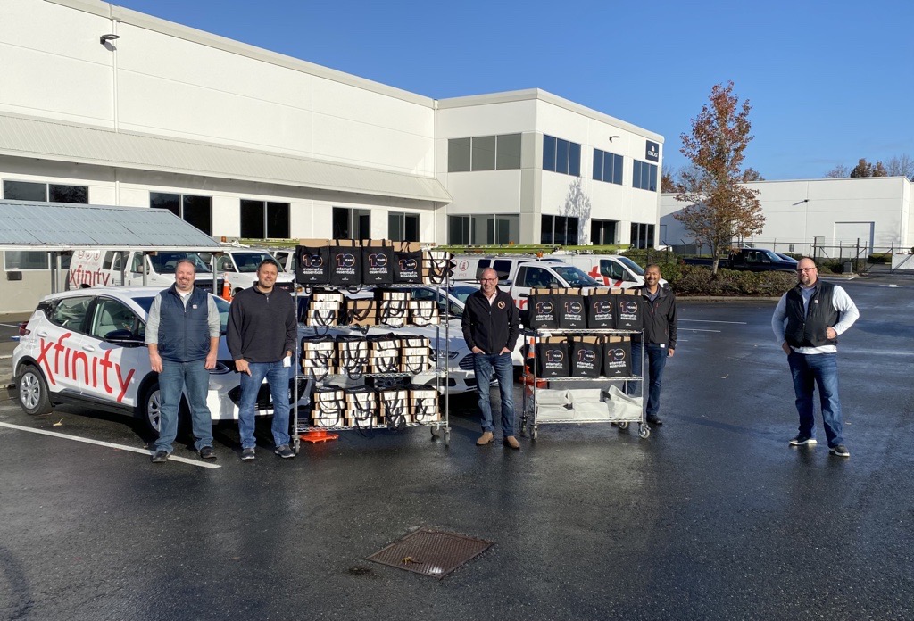 Comcast employees who are Veterans pose with Michael Schindler of Operation Military Family and donated laptops.