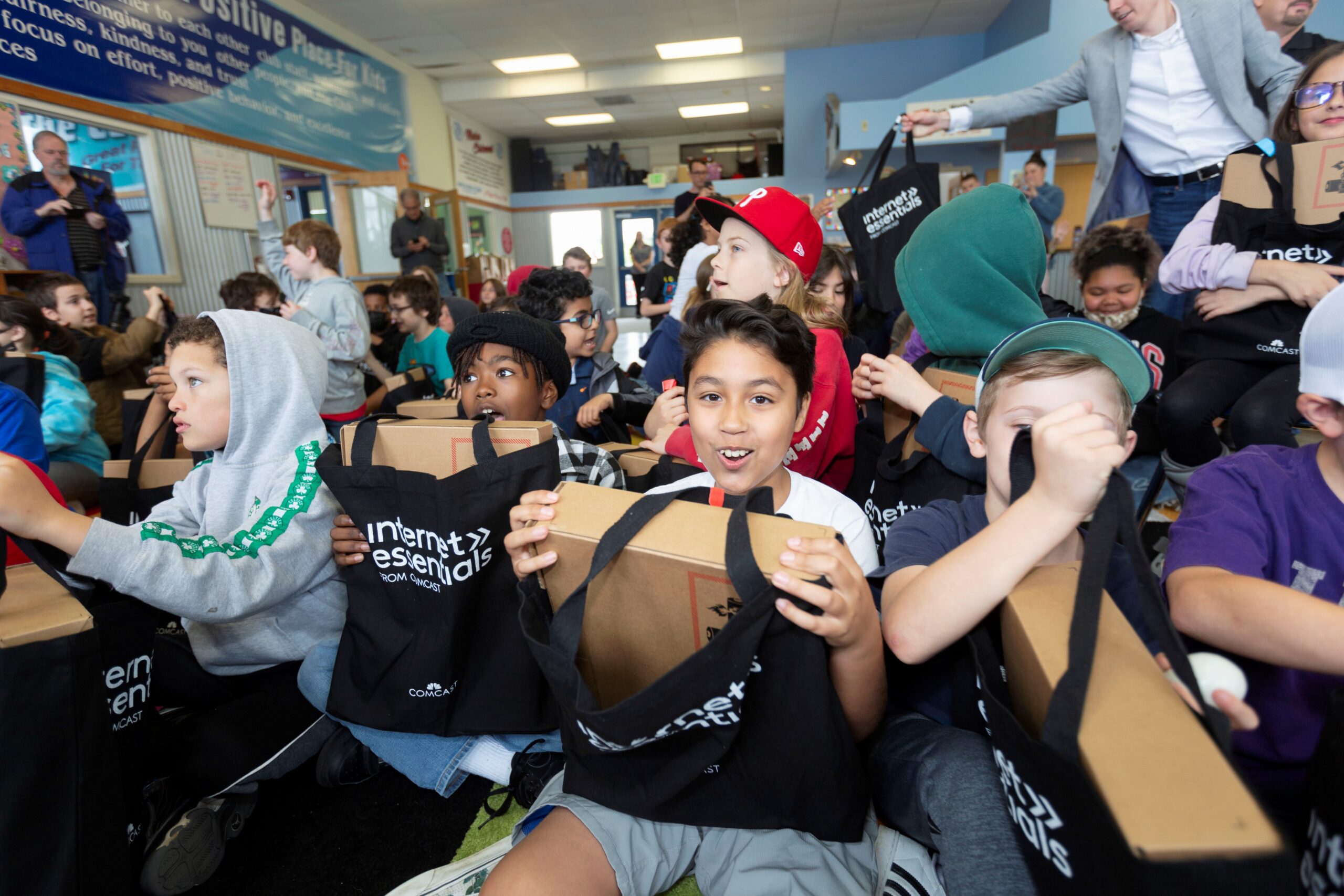 Children at the Boys and Girls Club smile with laptop bags.