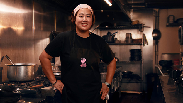 A woman stands in a restaurant kitchen