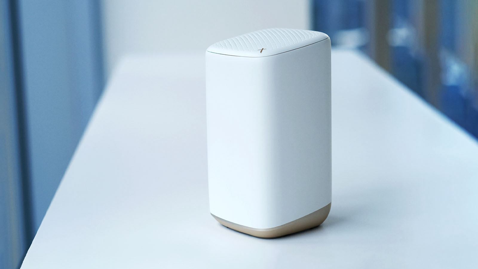 A white internet router rests on a table.