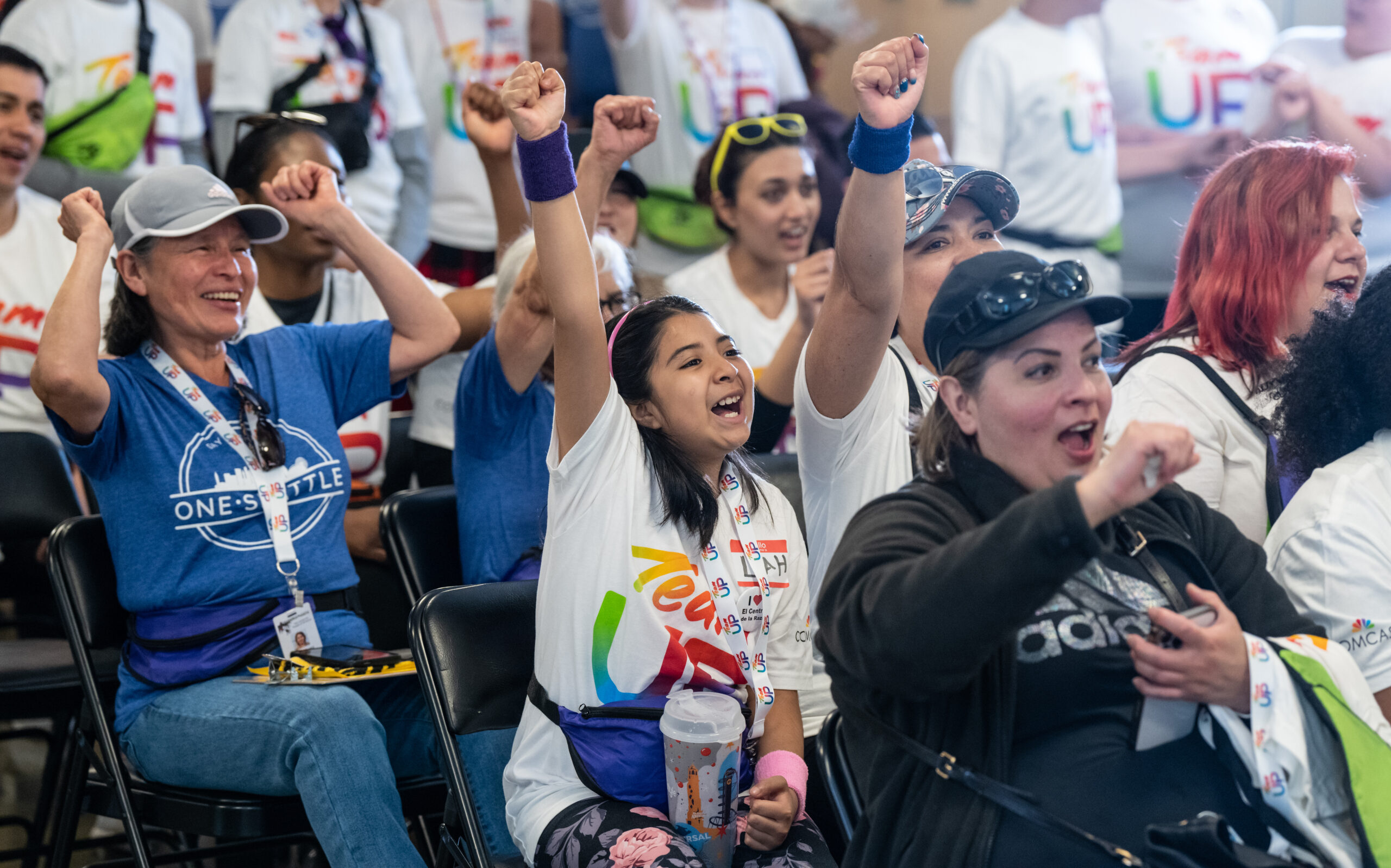 Volunteers at El Centro de la Raza raise their fists and cheer. 