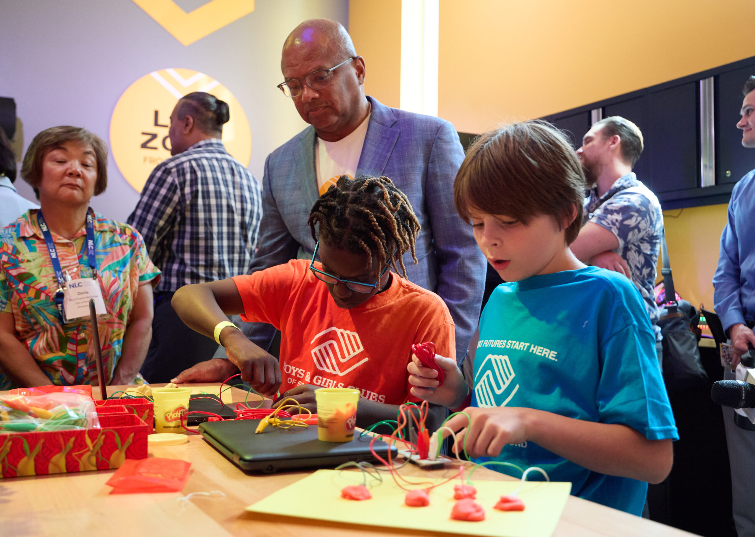 Broderick Johnson, of Comcast, watches children work with equipment