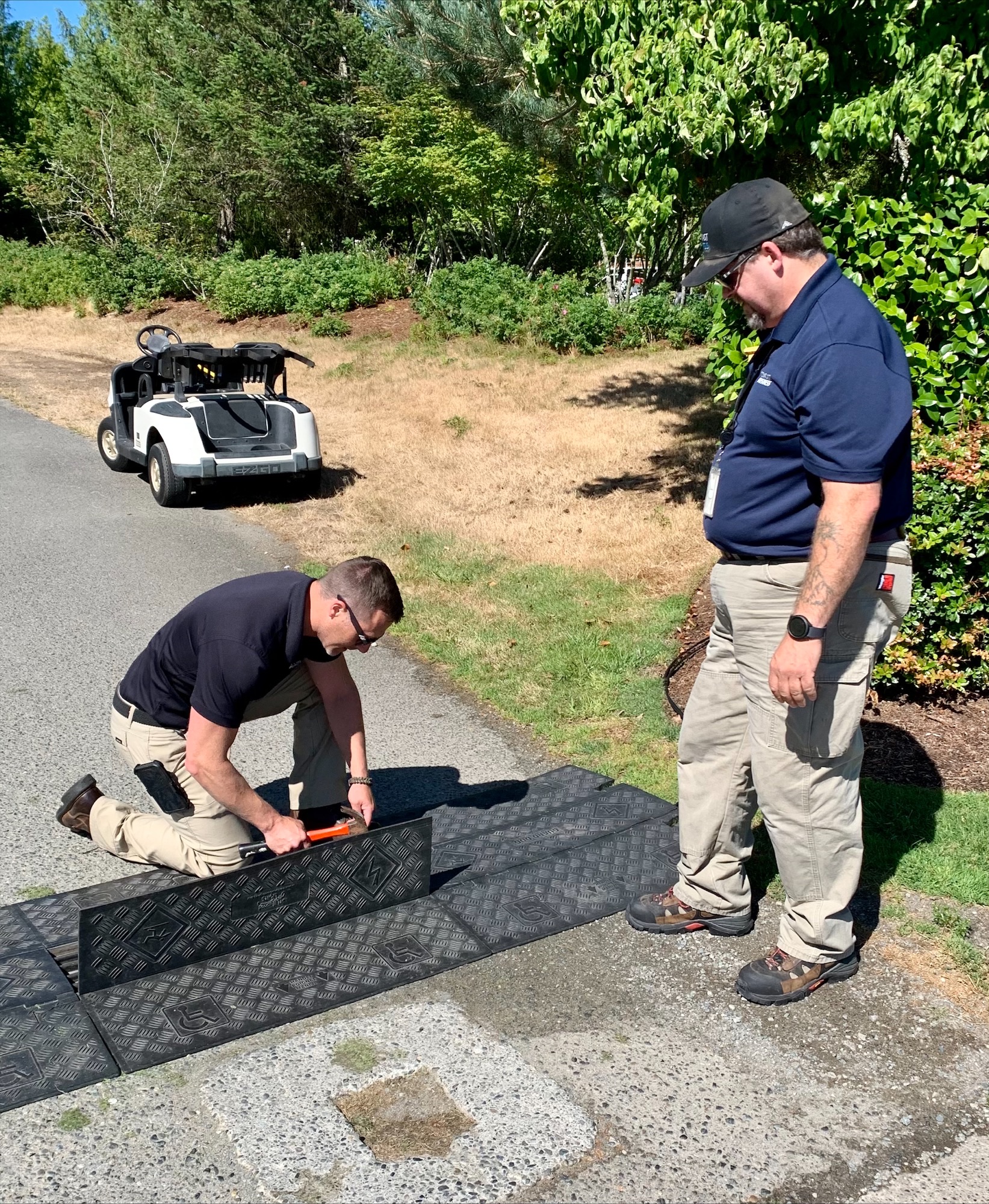 Comcast Technicians work on cable on a golf course.