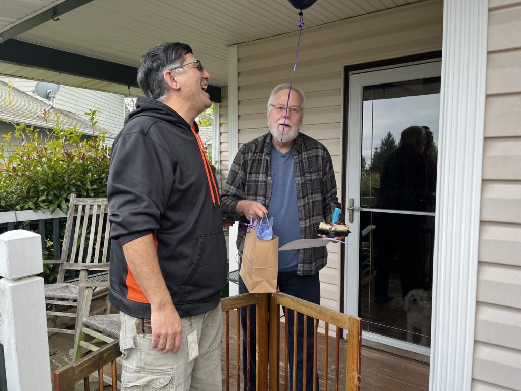 A Comcast customer receives balloons from a Comcast employee. 