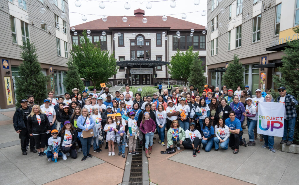 A group of over 100 volunteers pose at El Centro de la Raza.