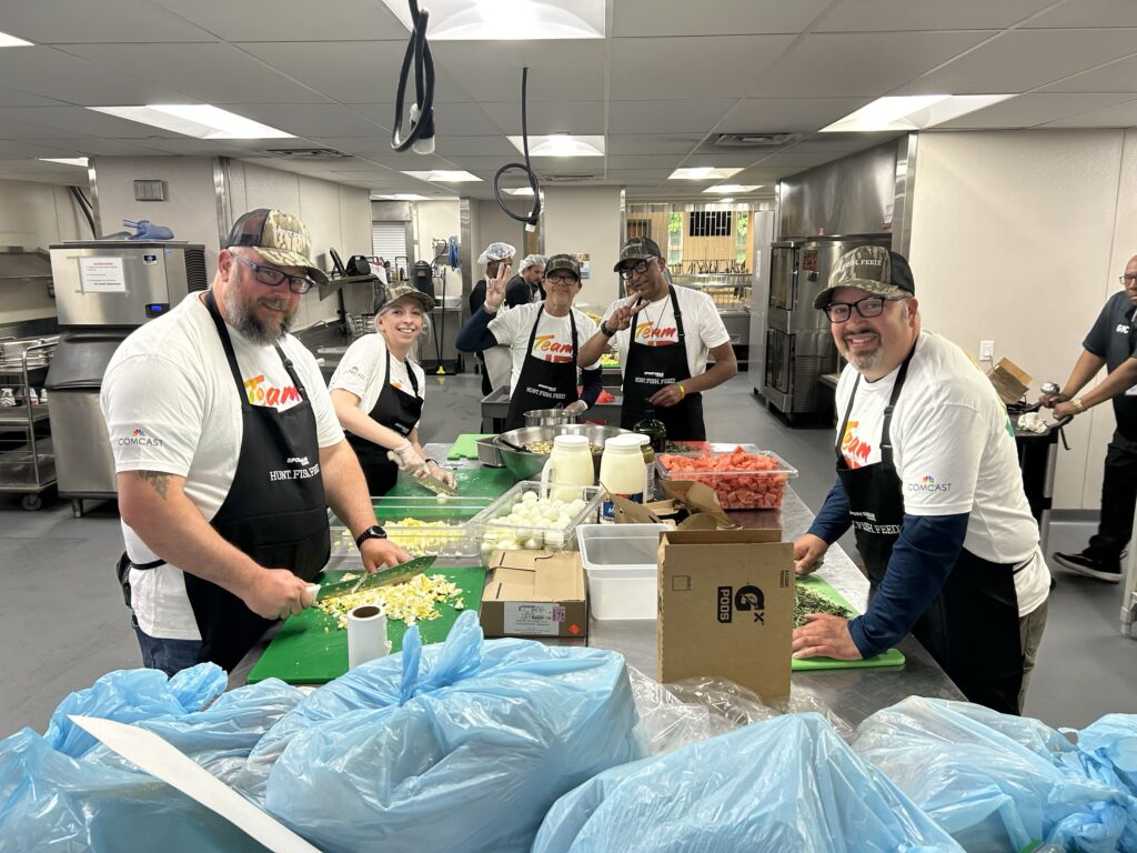 Volunteers prepare food in a kitchen. 