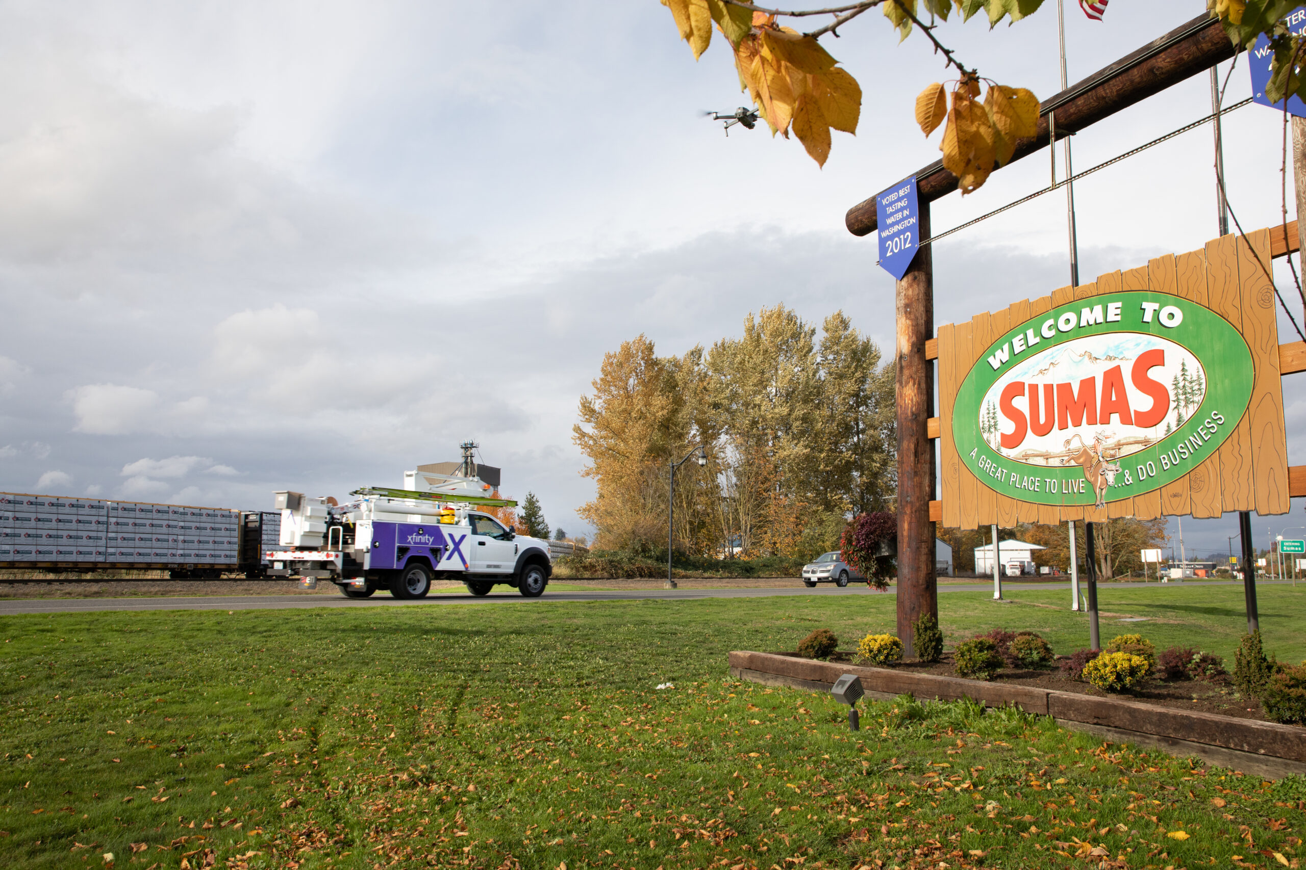 An Xfinity truck drives by a Welcome to Sumas sign.