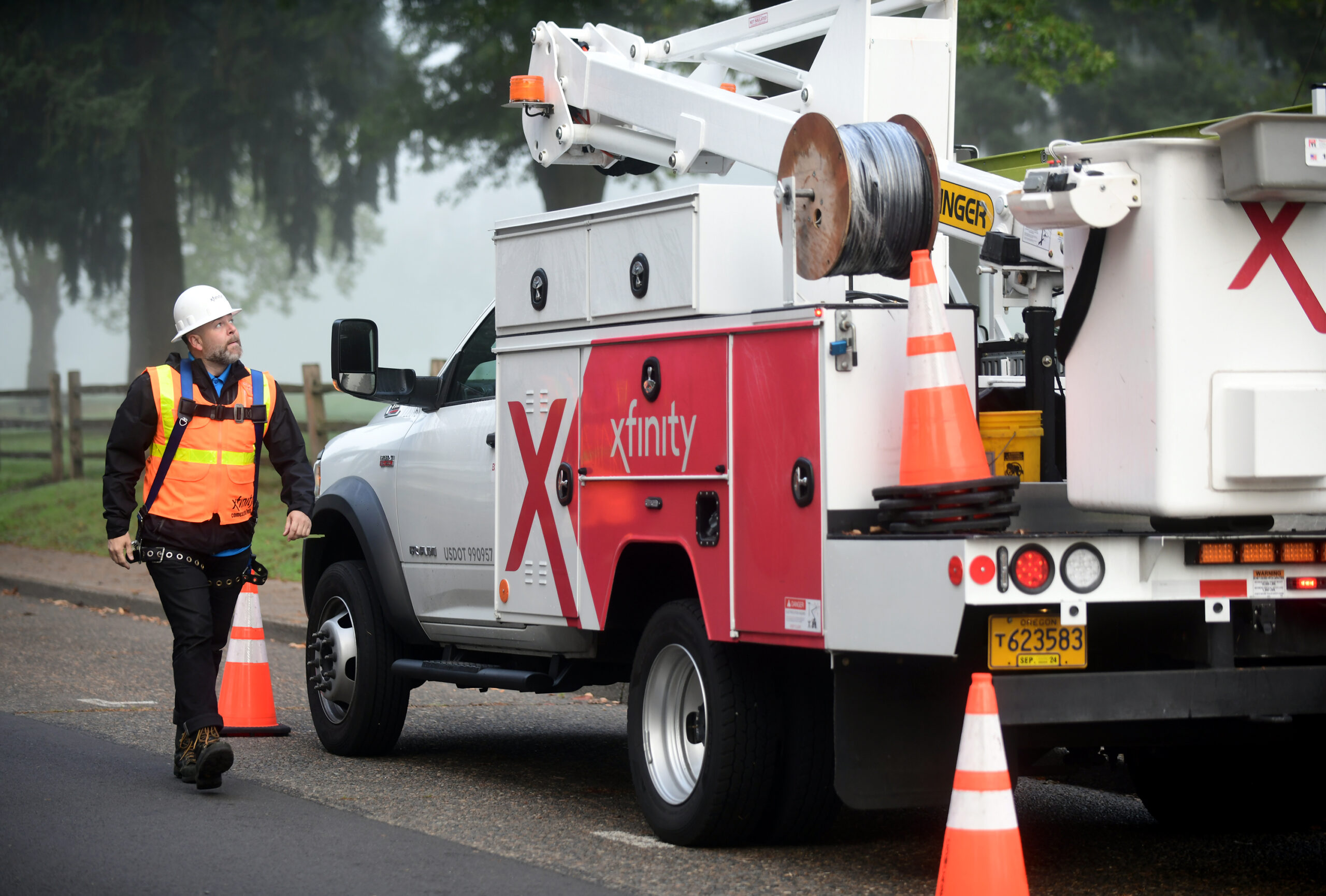 A Comcast technician walks next to an Xfinity truck.