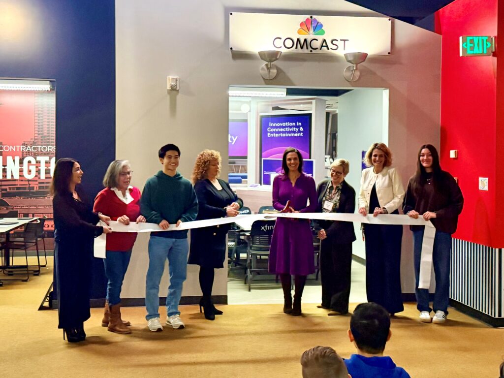 People cut a ribbon in front of the Comcast space in Finance Park at Junior Achievement.