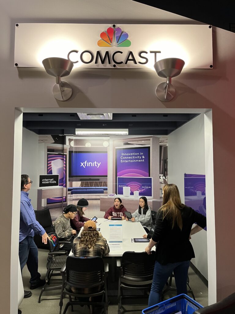 Students work with Comcast volunteers in the Comcast office in the Junior Achievement Finance Park.