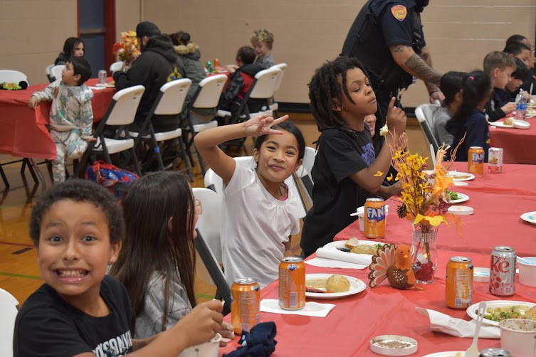 Children celebrate as they eat a holiday meal.