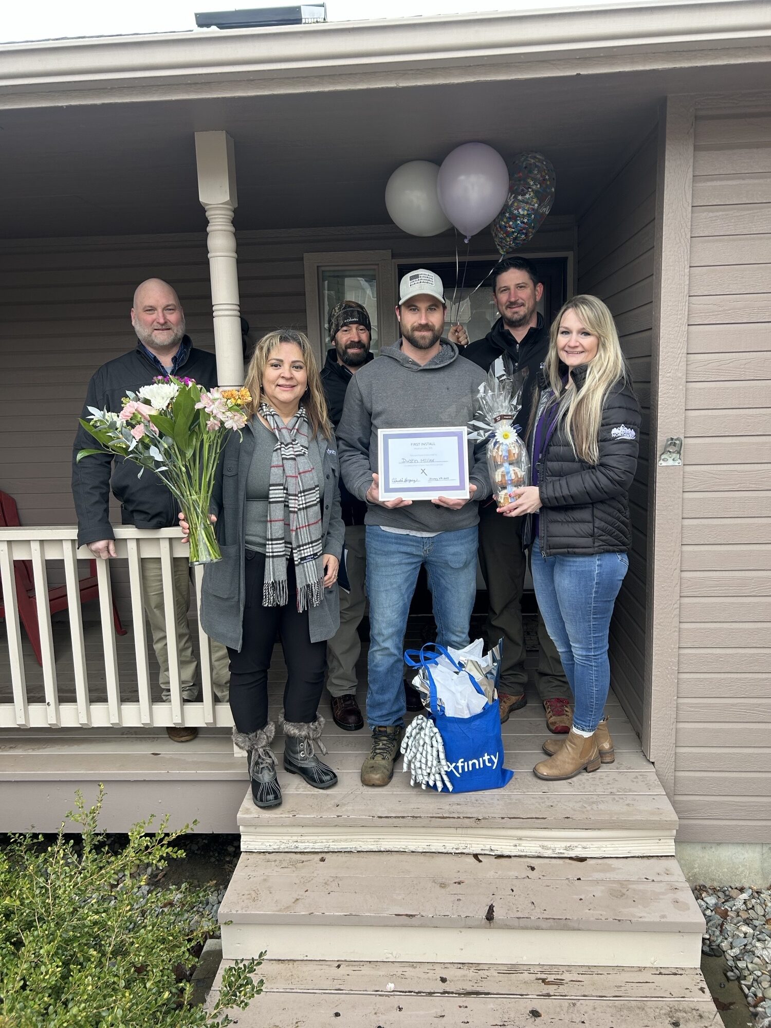 Dustin on his porch with Comcast reps.