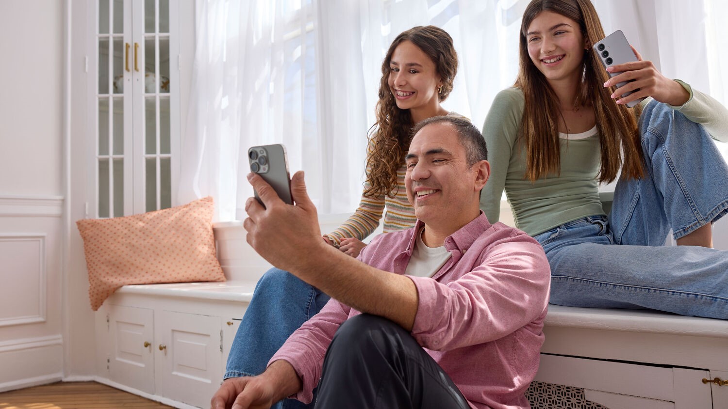 A family watches something on a phone.