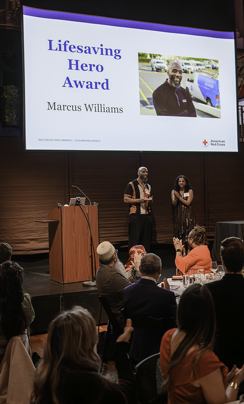 Marcus Williams receives award from Red Cross on stage.