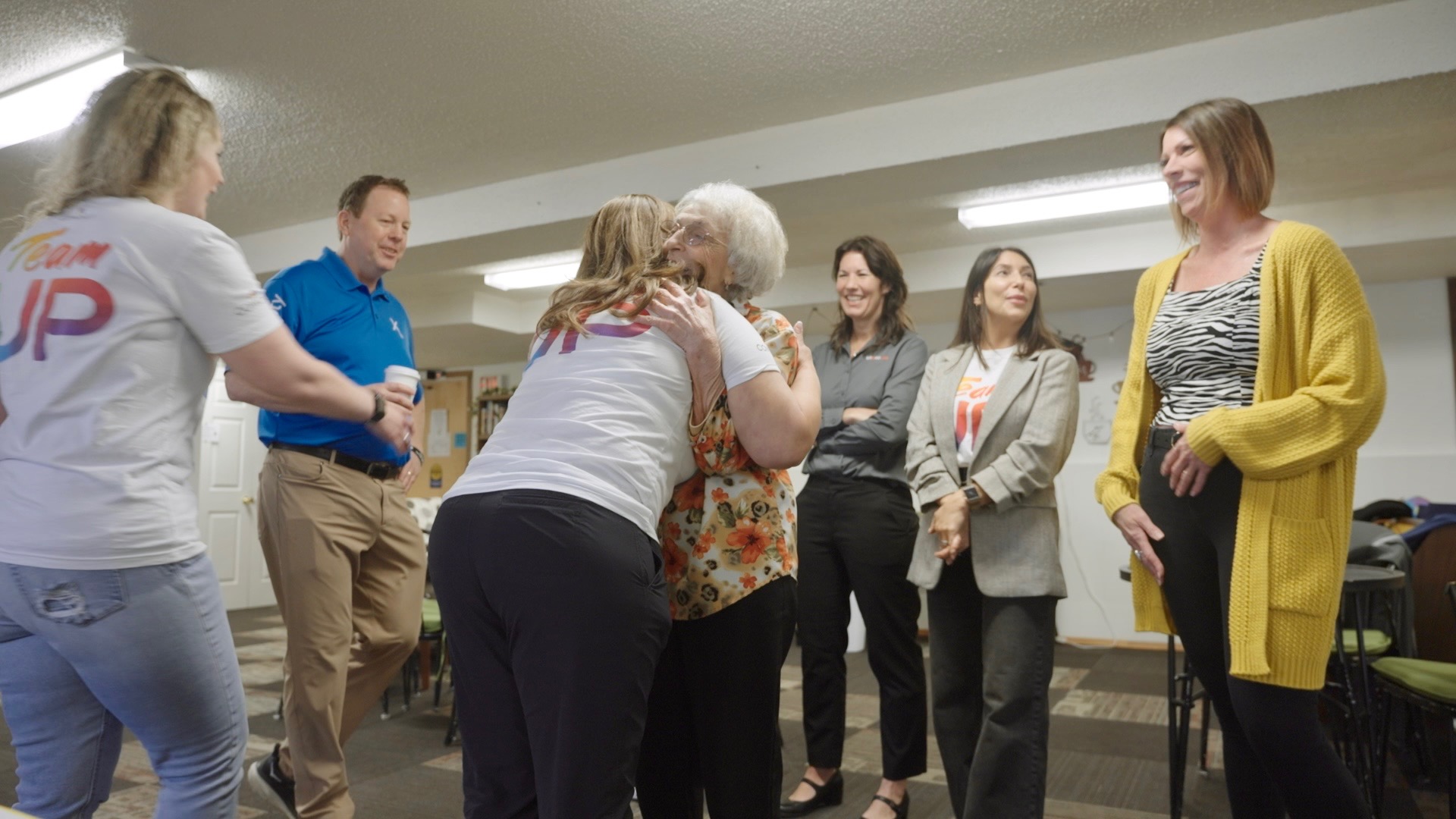 Comcast employee volunteers hug a Silver Cafe patron.
