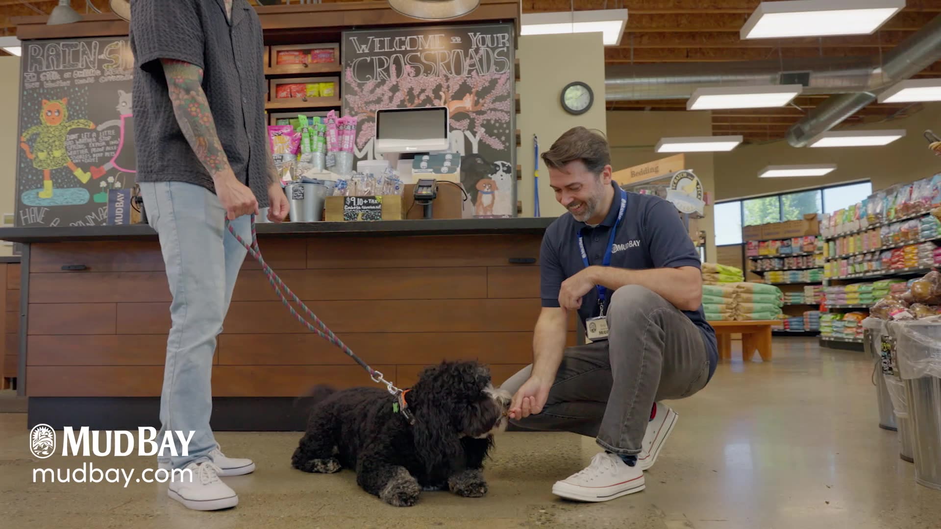A Mud Bay employee with a dog in a store.