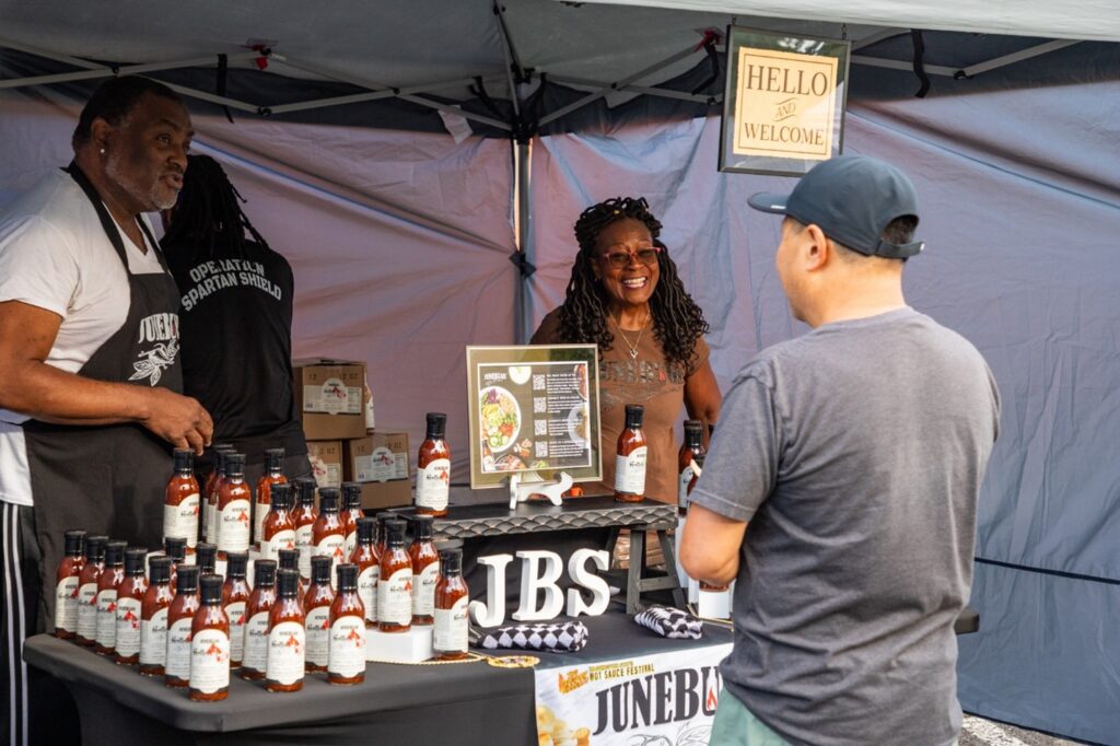 A woman sells people barbecue sauce.