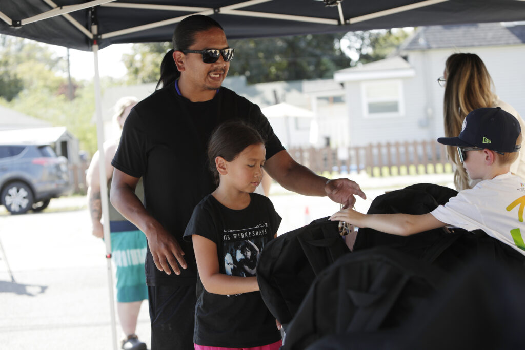 a father picks up a backpack with his daughter.