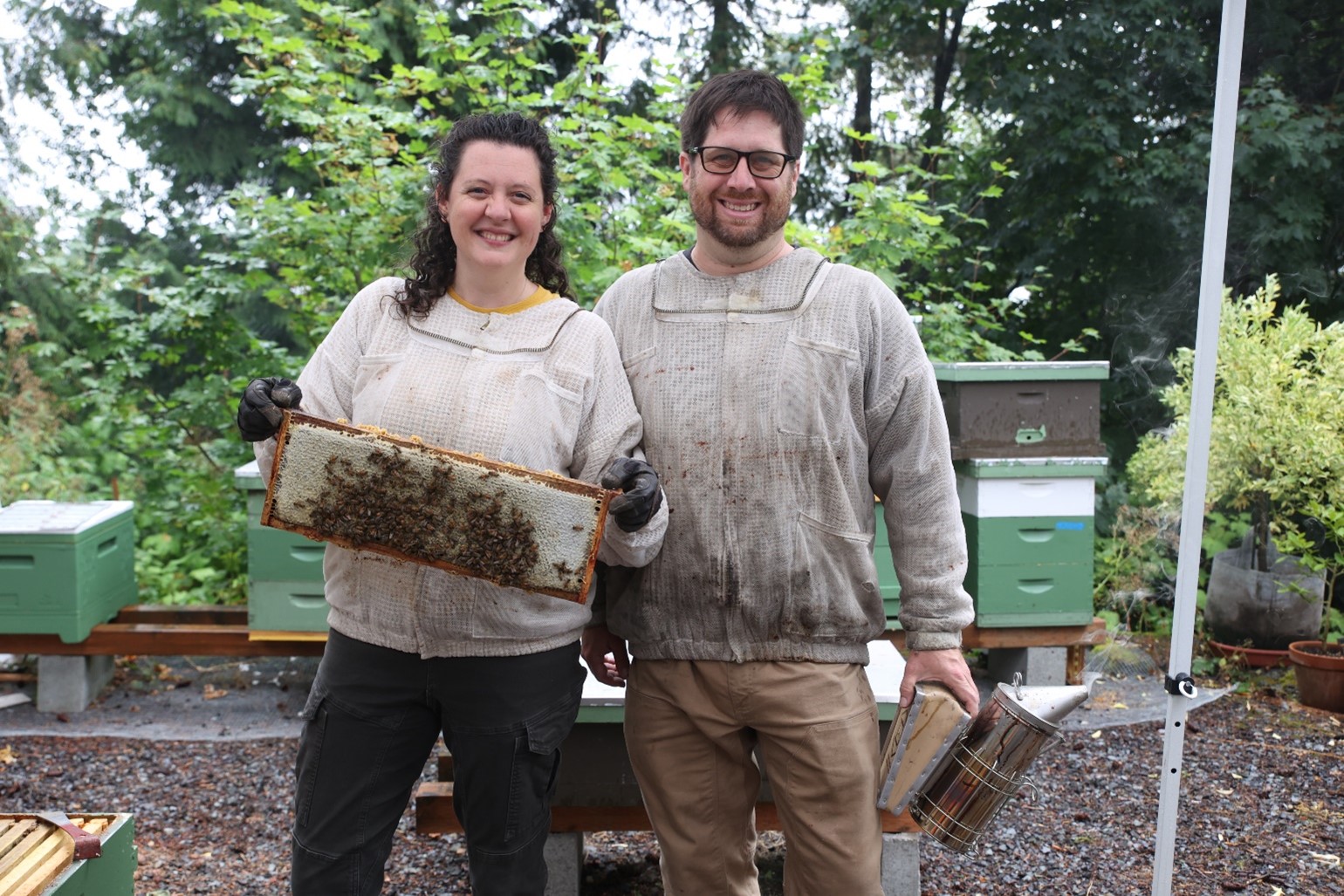 The owners of Rainy Day Bees in a garden.