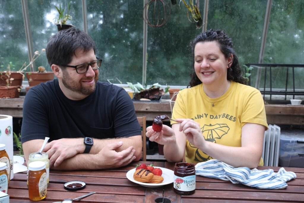 The owners of Rainy Day Bees in a house with food.